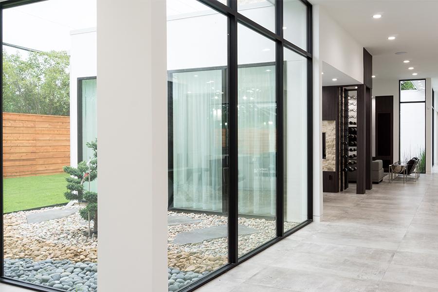 Modern white hallway with floor-to-ceiling black window wall