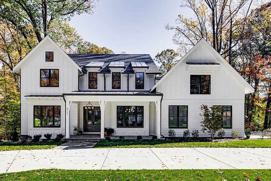 A modern farmhouse features shed dormers with Andersen black framed windows