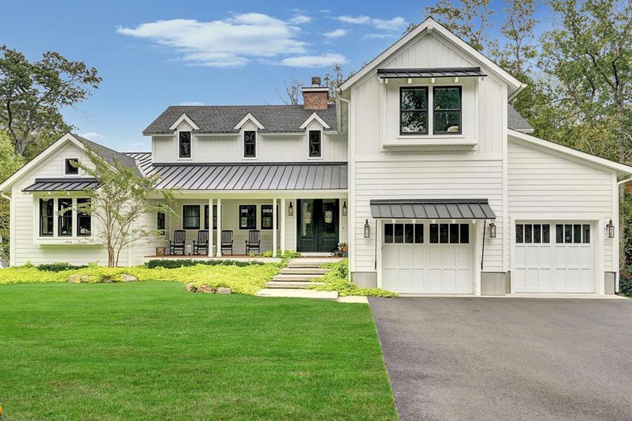 A modern farmhouse features a series of three gabled dormer Andersen windows