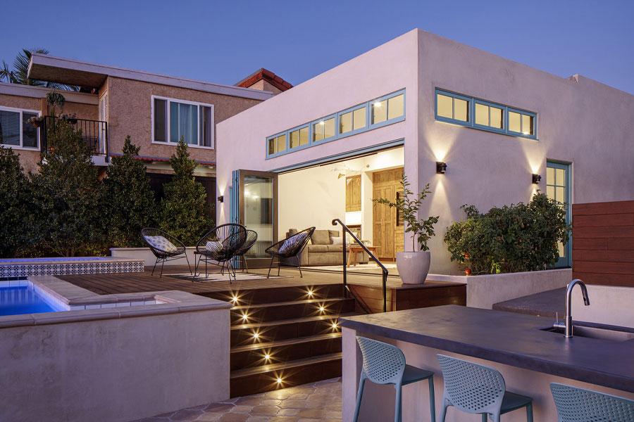 A bifolding door is opened to connect a family room with the raised deck outside