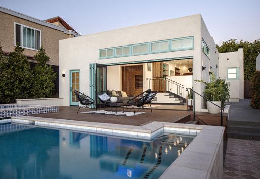  A backyard swimming pool and deck connect to the house through a bifolding door