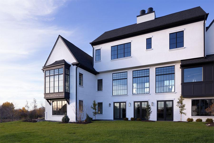 A white Tudor home with contrasting black accents including roof, doors, and windows.