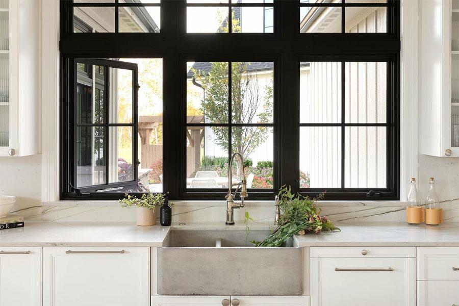 A double row of black casement windows above a kitchen sink.