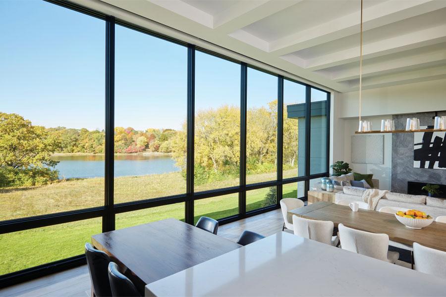 A kitchen and porch with floor-to-ceiling windows facing a backyard swimming pool.