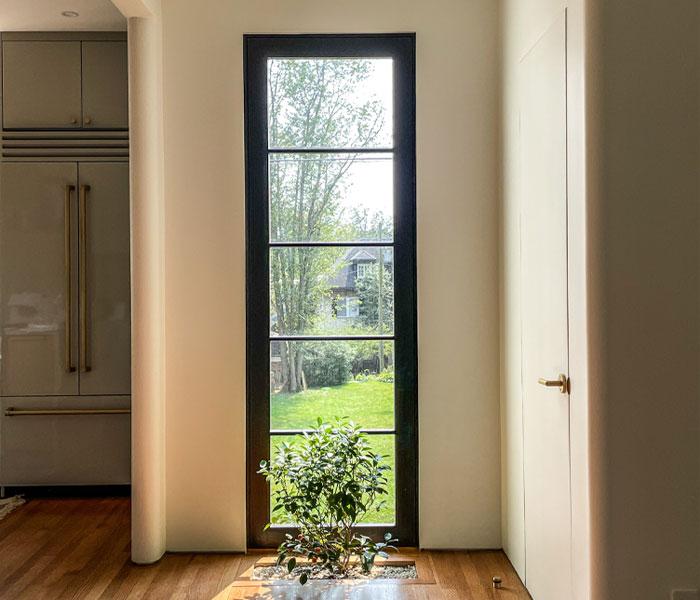 An in-floor planter takes full advantage of the light brought into a corner of this kitchen by a floor-to-ceiling window.