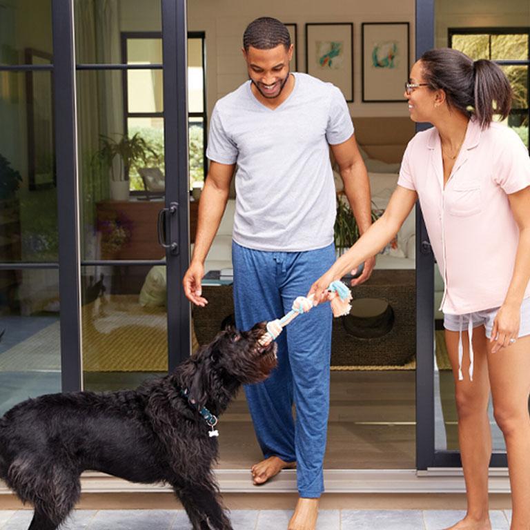 A sliding patio door lets this couple and their dog move seamlessly from the bedroom to playtime on the patio