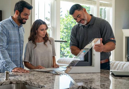 Replacement contractor showing clients a window model in a kitchen