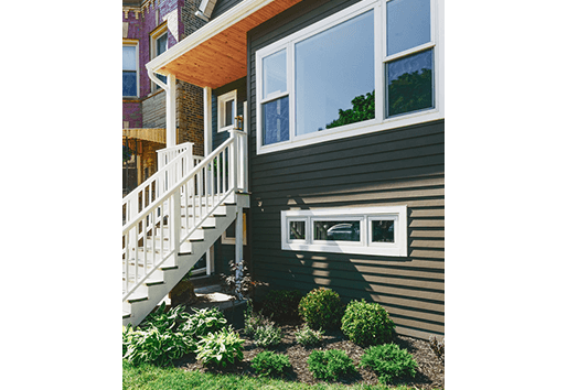 Exterior view of home with basement and main level white windows