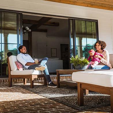 Couple sitting outside enjoying fresh air with large Andersen sliding door